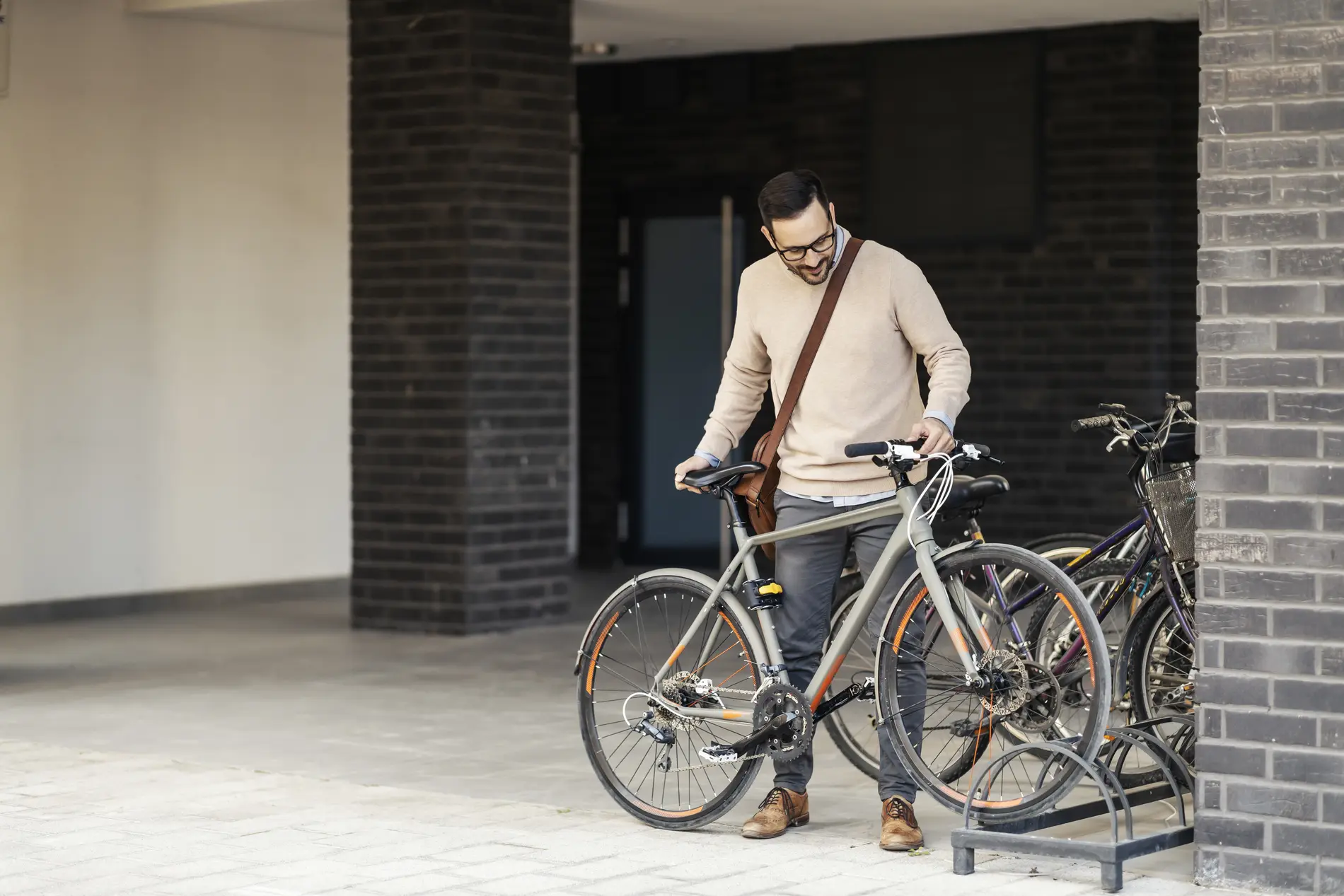 Mann stellt Fahrrad bei Abstellanlage ab